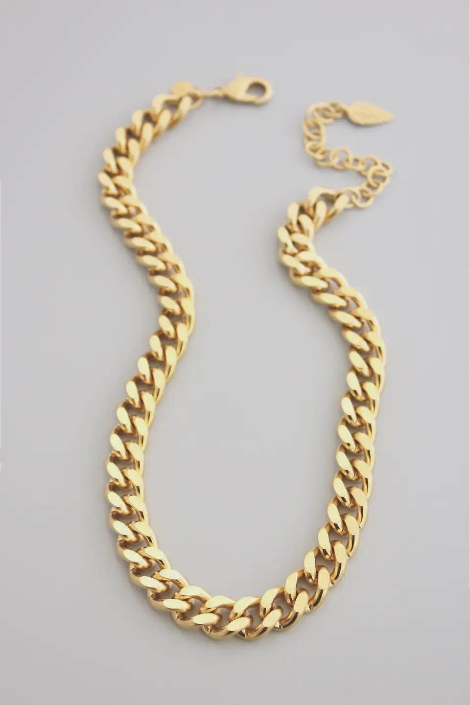 Gold chain necklace on a gray background