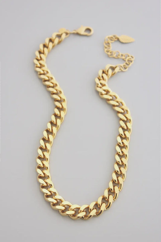 Gold chain necklace on a gray background