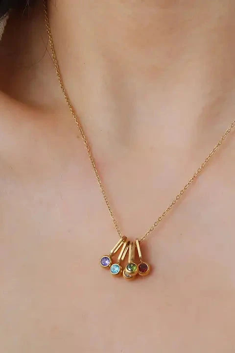 Gold necklace with multicolored gemstones on a person's neck