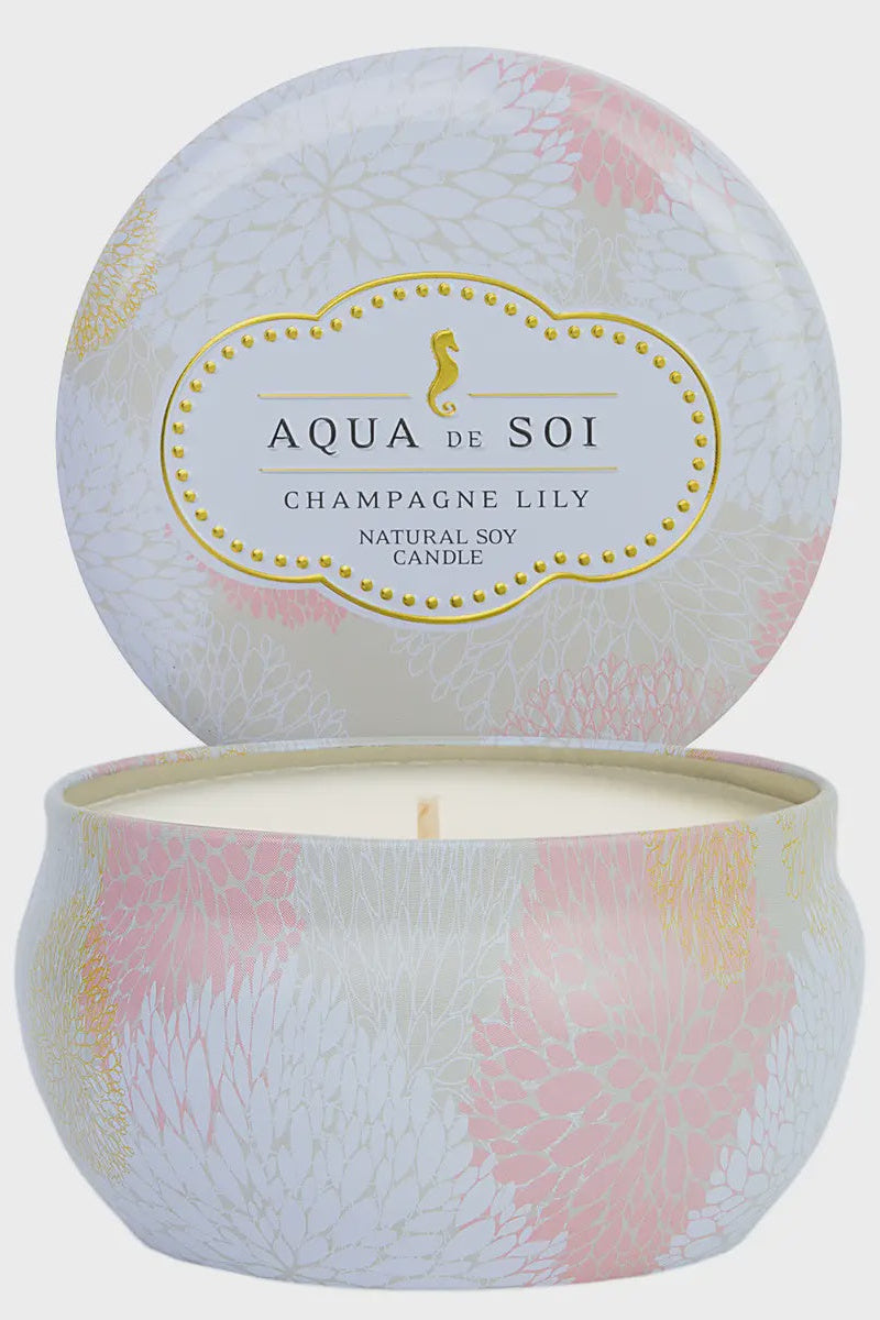 Candle in a decorative container with 'Aqua de Soi' branding on a light gray background