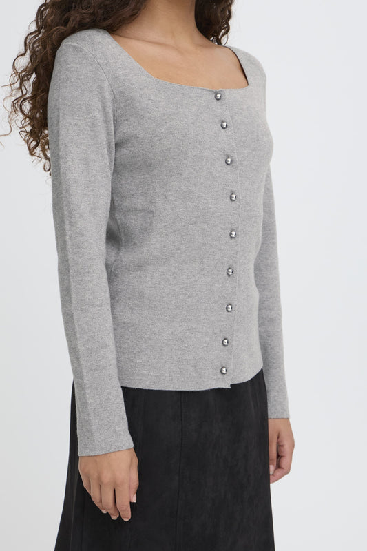Gray cardigan with button details worn by a person on a white background