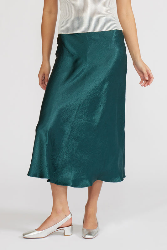 Person wearing a green satin skirt on a white background