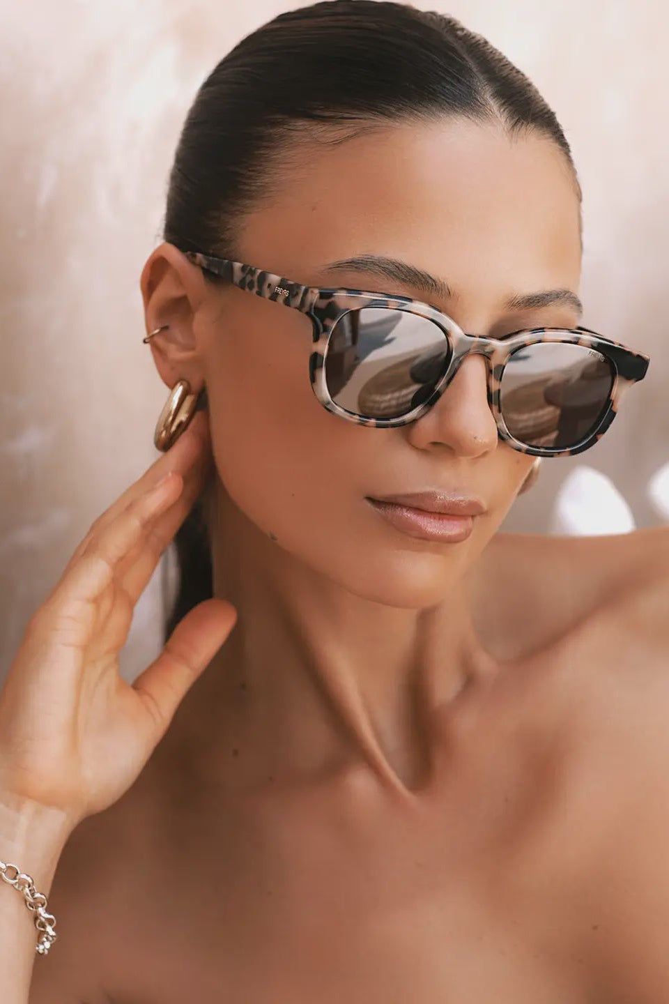 Woman wearing sunglasses with a neutral background