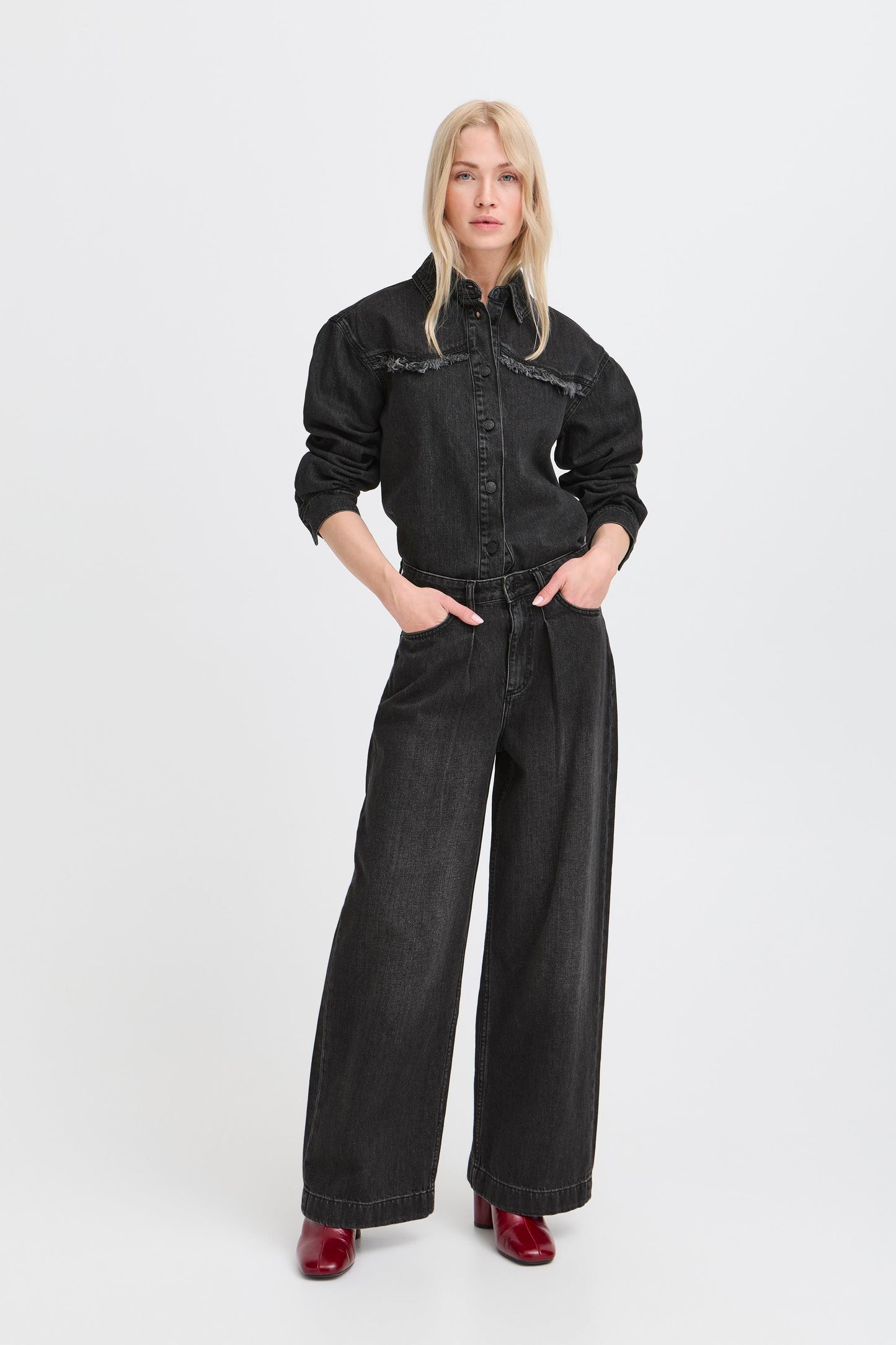Woman wearing a black denim outfit on a white background
