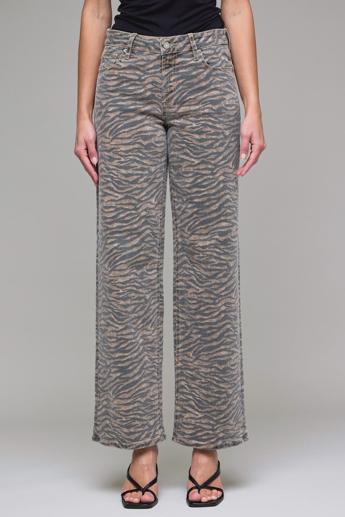 Person wearing zebra print pants on a plain background