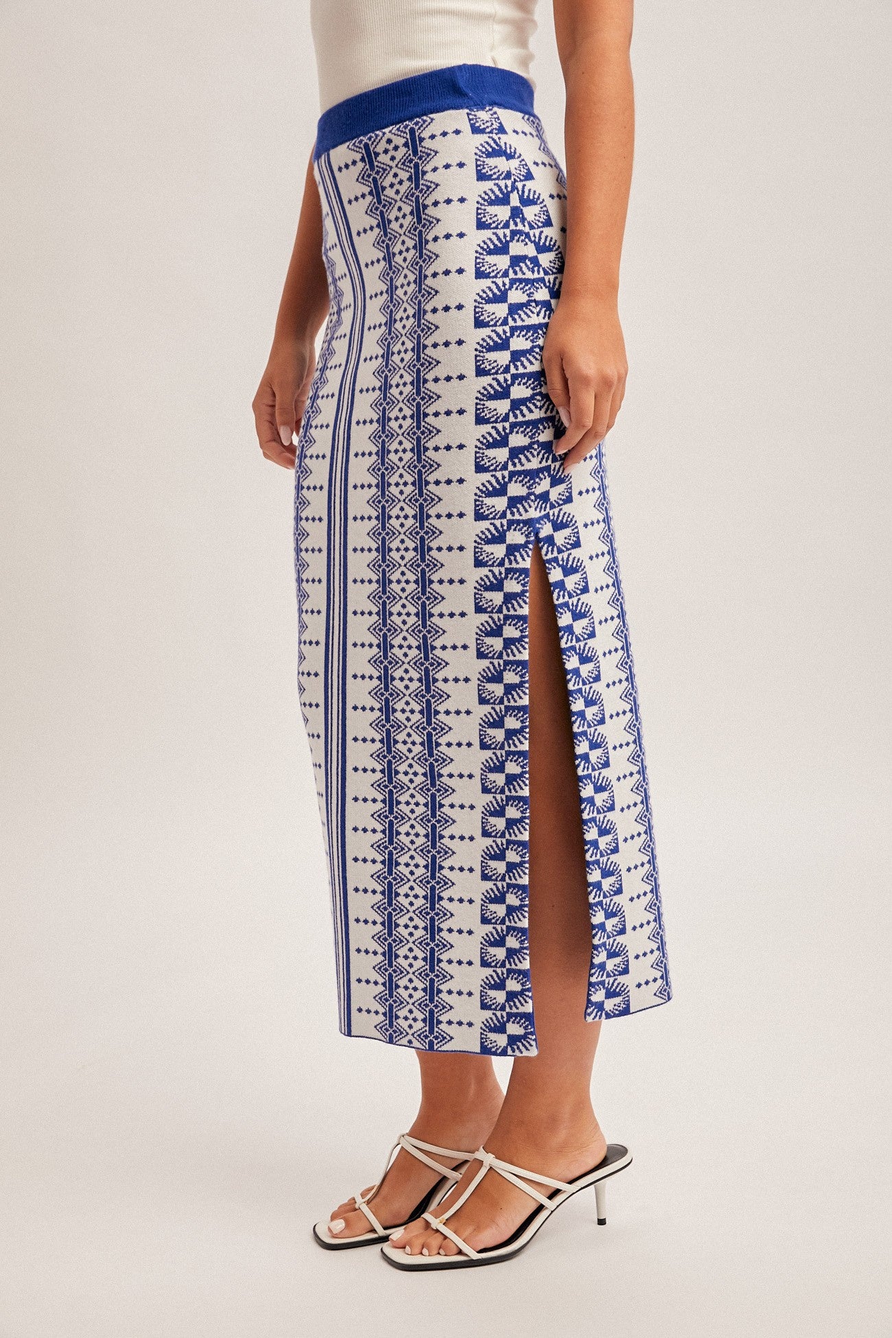 Person wearing a blue and white patterned skirt on a plain background