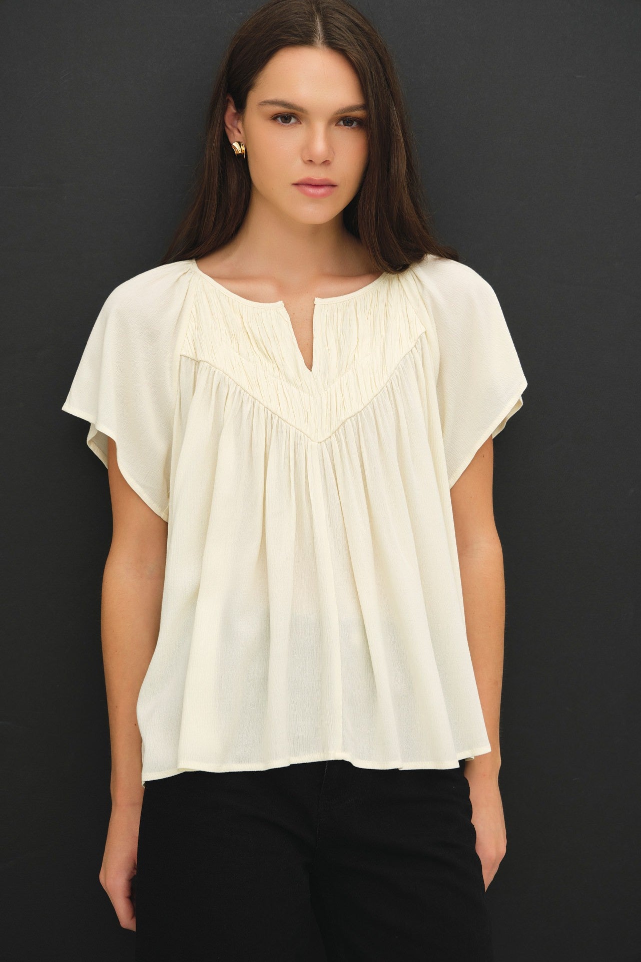 Woman wearing a white blouse against a black background
