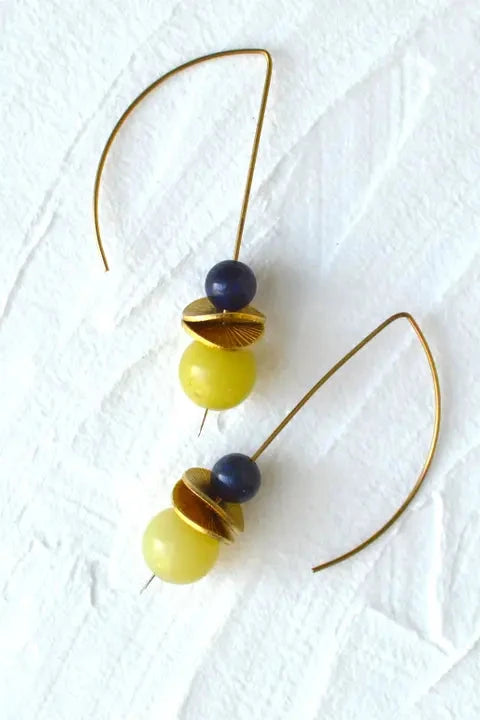 Earrings with yellow and blue beads on gold hooks against a white background
