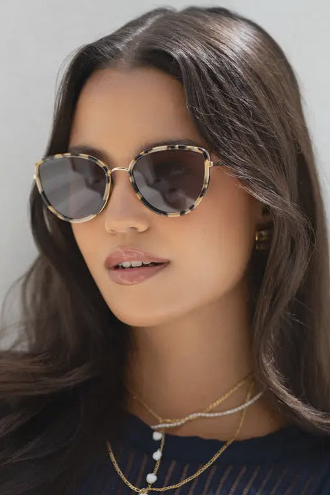 Woman wearing sunglasses with a neutral background