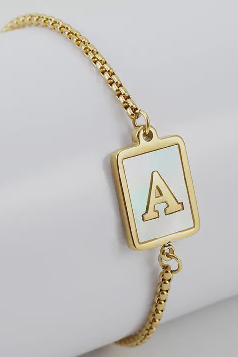 A gold-plated stainless steel bracelet with a square charm featuring the letter 'A' on a white background.