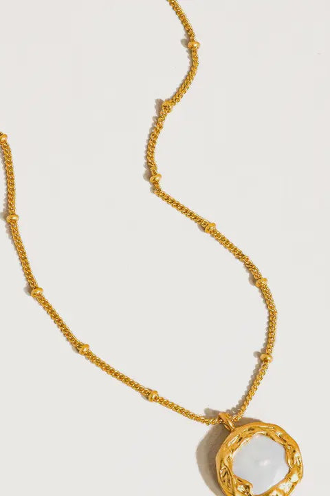 An 18k vintage gold natural pearl round necklace with a brass pendant and gold plating, displayed against a white background.