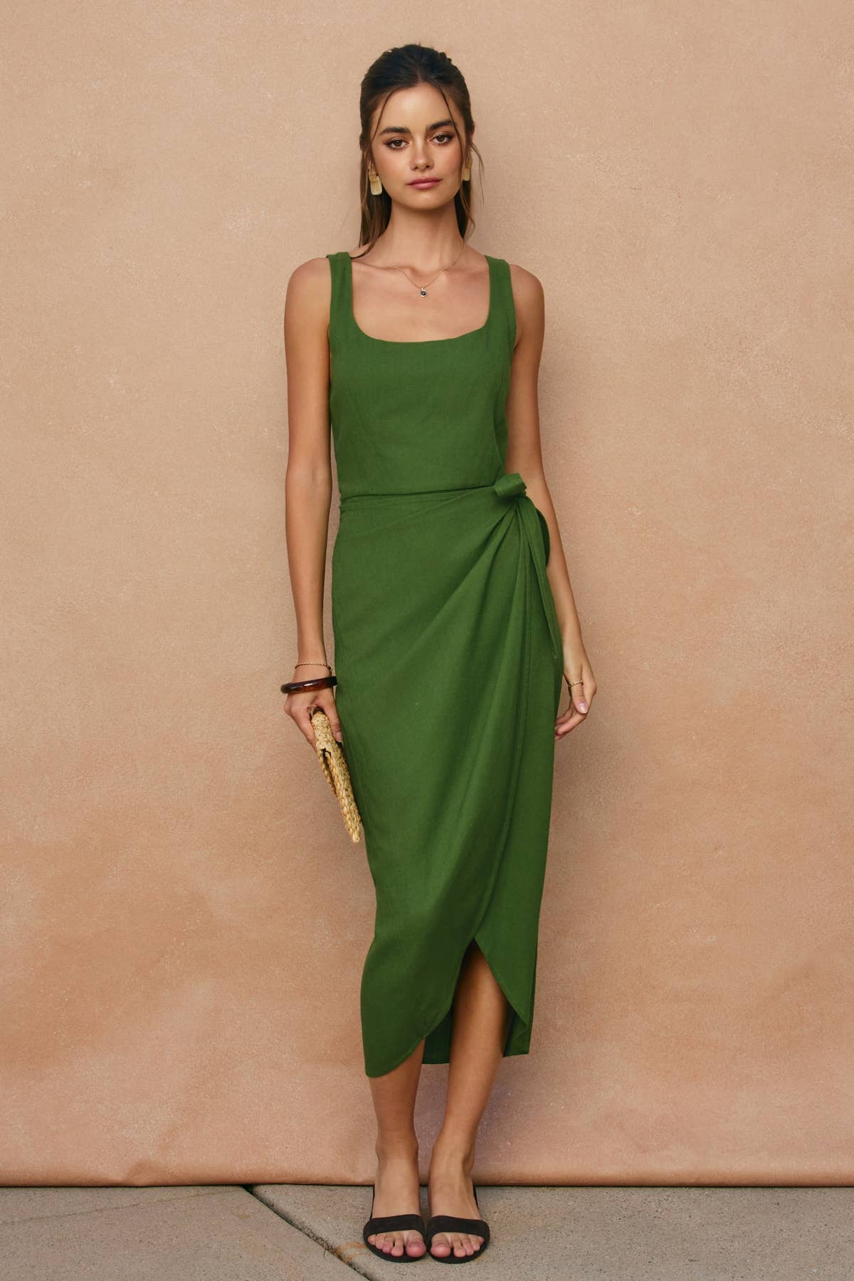 Woman wearing a green dress against a beige background