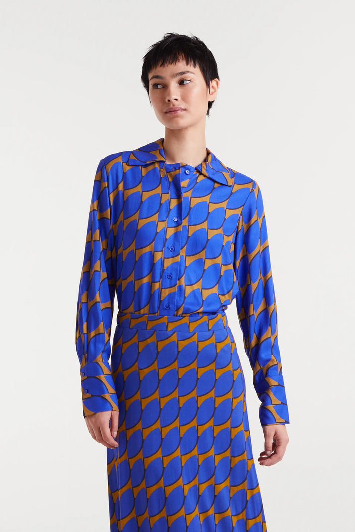 Person wearing a blue and orange patterned dress on a white background