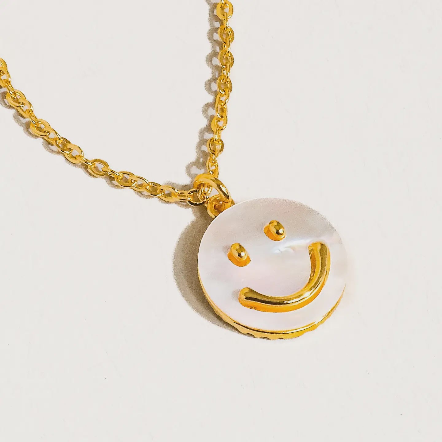 smiley face necklace Mae of gold-plated brass and natural shell
