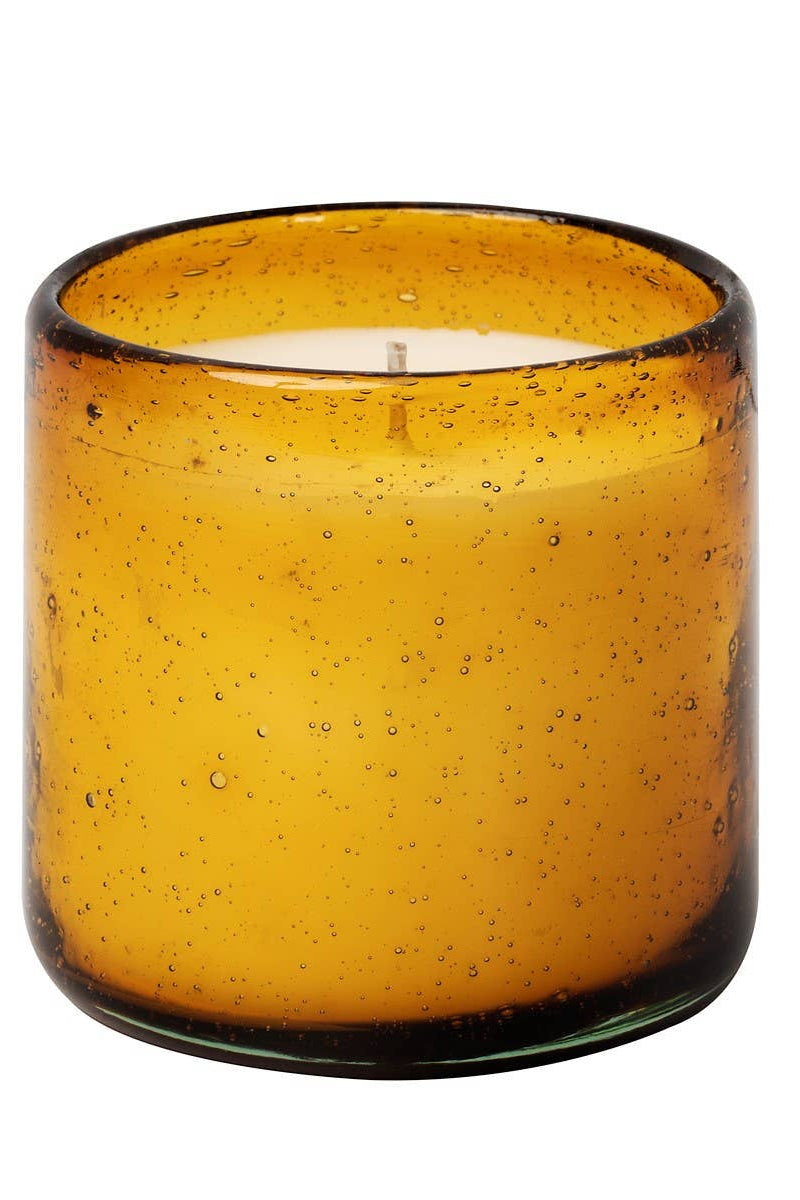 Amber glass candle holder with a candle inside on a white background