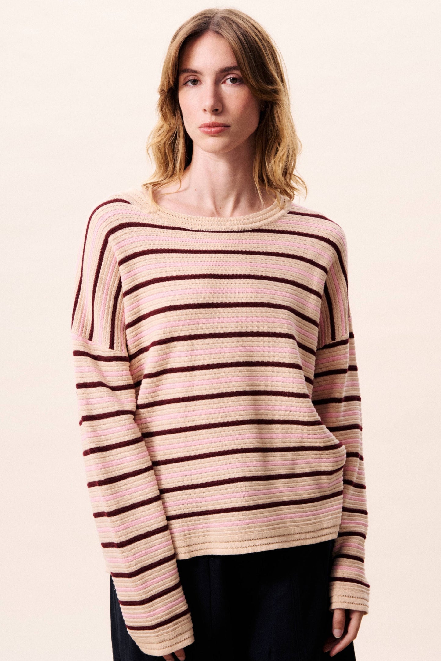 Woman wearing a striped sweater on a plain background