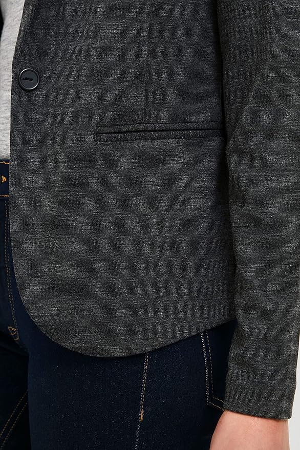 Close-up of a dark gray blazer with a button and pocket detail.