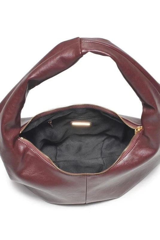 Brown leather handbag with open top on a white background