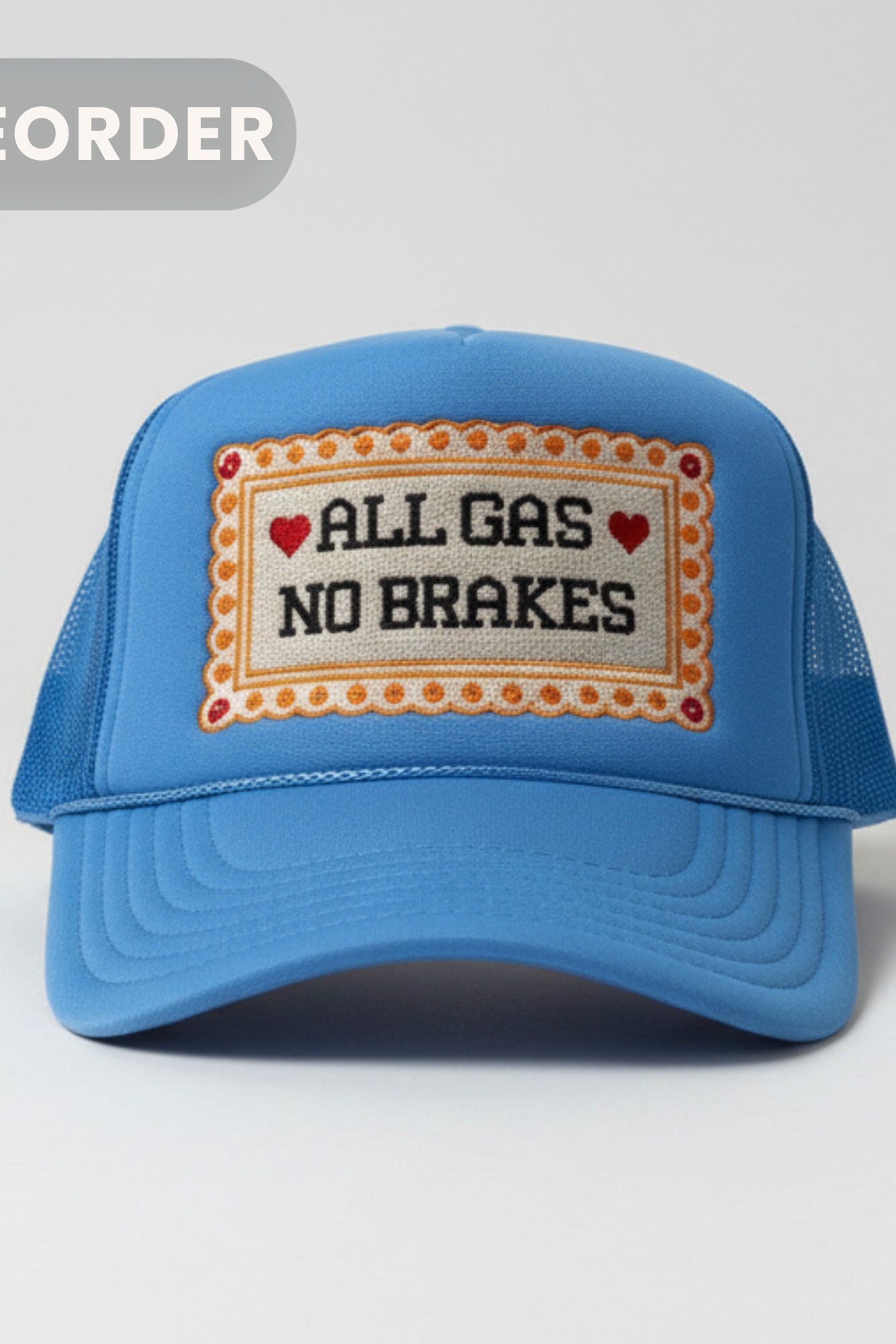 A blue trucker-style cap with a front patch reading 'ALL GAS NO BRAKES' in black text with red hearts, shown on a light gray background. A gray 'PREORDER' badge appears in the top-left corner.