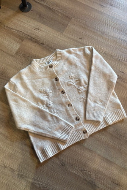 Beige cardigan on a wooden floor