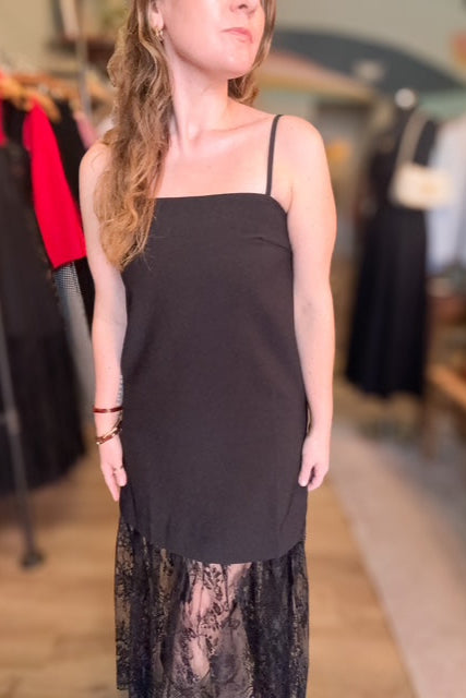 Woman wearing a black top with a lace skirt in a clothing store.