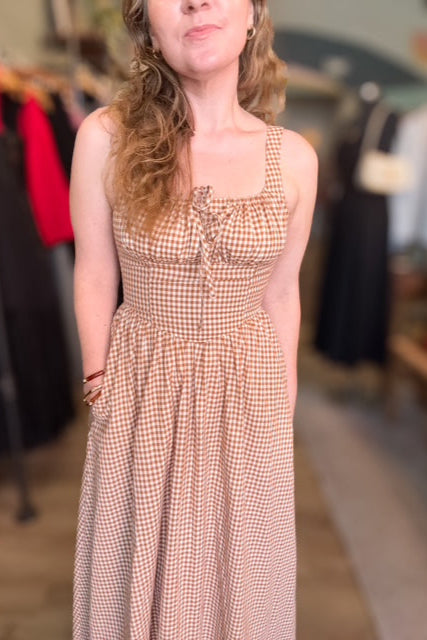 Woman wearing a checkered dress in a clothing store setting