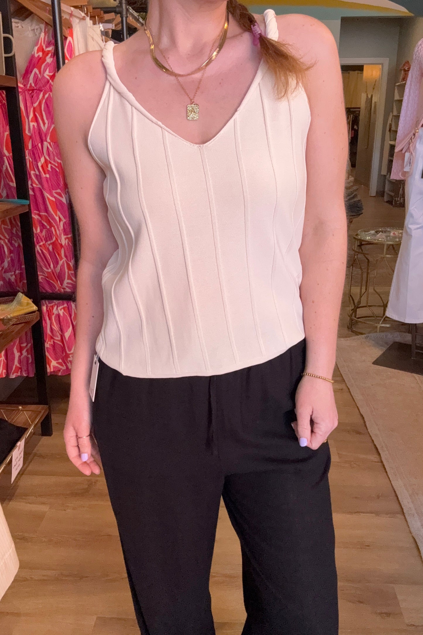 Person wearing a white top and black pants in a store setting