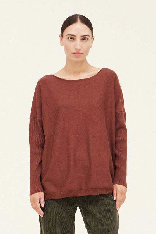 Woman wearing a brown sweater on a beige background