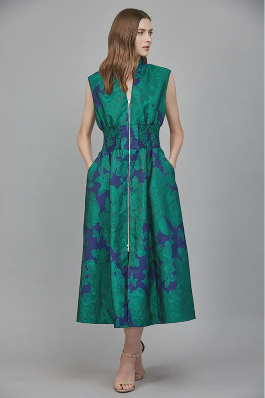 Woman wearing a green and blue patterned dress on a gray background