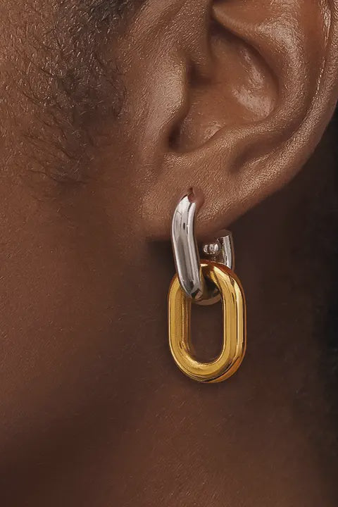 Close-up of an ear wearing a gold and silver hoop earring.