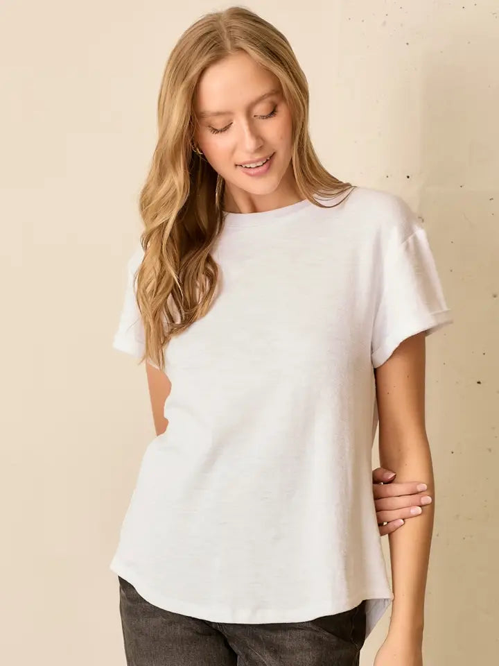 Woman wearing a white t-shirt against a beige background