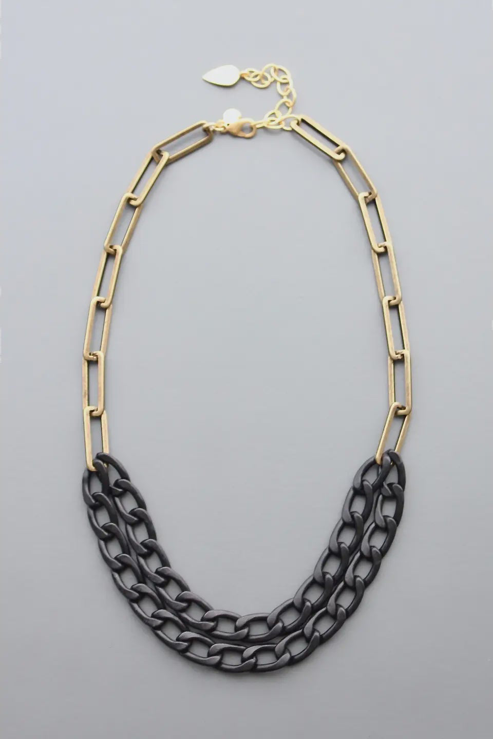 Necklace with gold and black chain links on a gray background