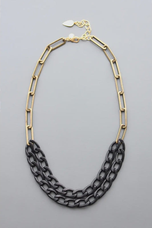 Necklace with gold and black chain links on a gray background