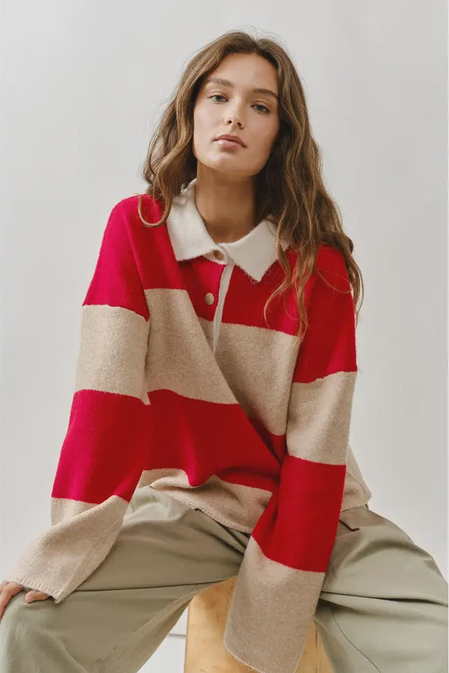 Woman wearing a red and beige striped sweater with a white collar.