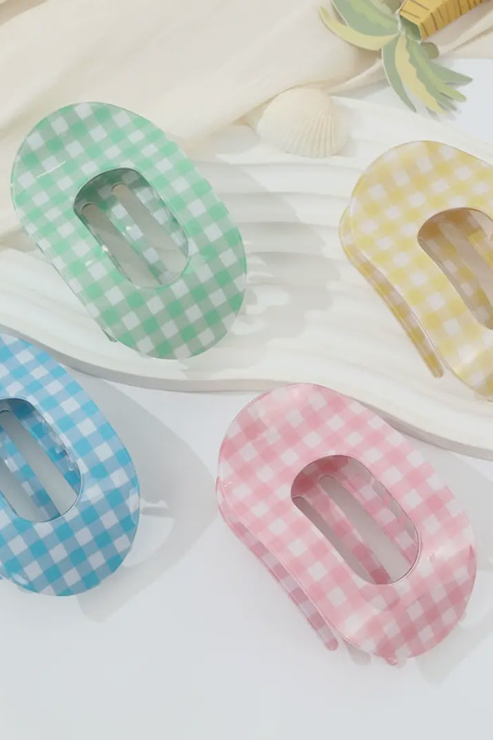 Four colorful gingham checkered hair clips on a light background