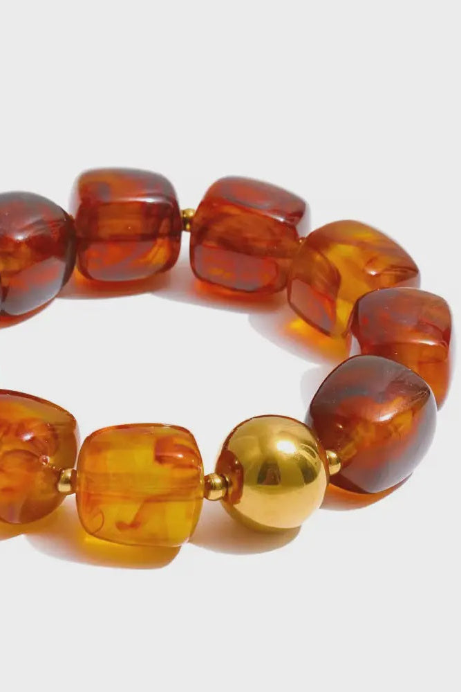 Bracelet with amber-colored beads on a white background