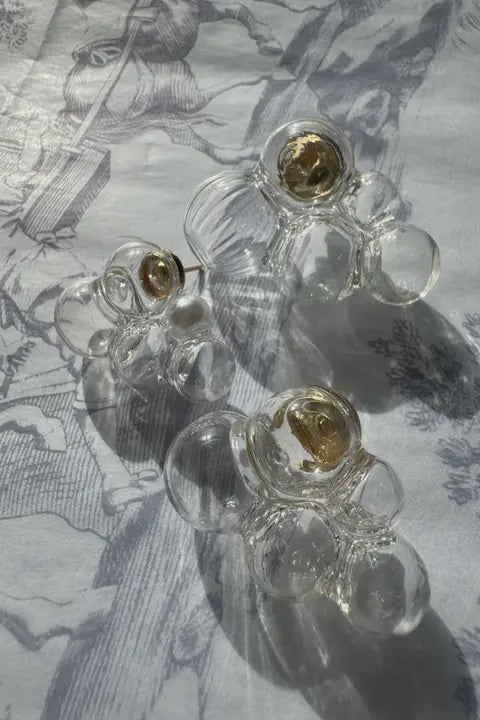 This image features a pair of elegant glass bubble earrings from the Cloud Collection. The earrings are designed with a captivating, bubble-like form, smoothly transitioning from a clear to a lightly tinted glass, which gives them a unique, ethereal appearance.