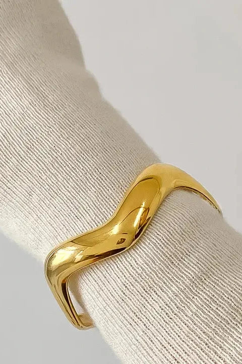 Gold bracelet on a white textured surface