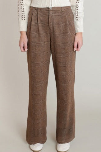 Brown plaid pants worn by a person on a beige background