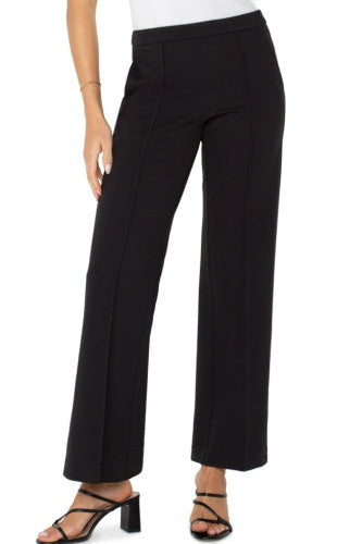 Black pants worn by a person on a white background