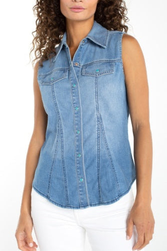 Woman wearing a sleeveless denim shirt with a plain background
