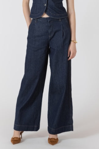 Person wearing dark blue denim pants and a matching jacket on a white background