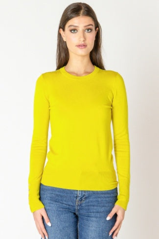 Woman wearing a yellow long-sleeve top and blue jeans on a white background