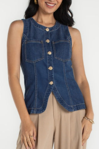 Woman wearing a denim vest over a beige top on a white background