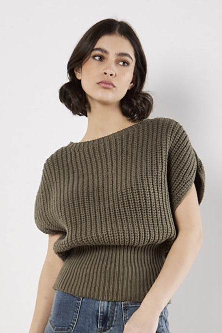 Woman wearing a brown ribbed sweater against a white background
