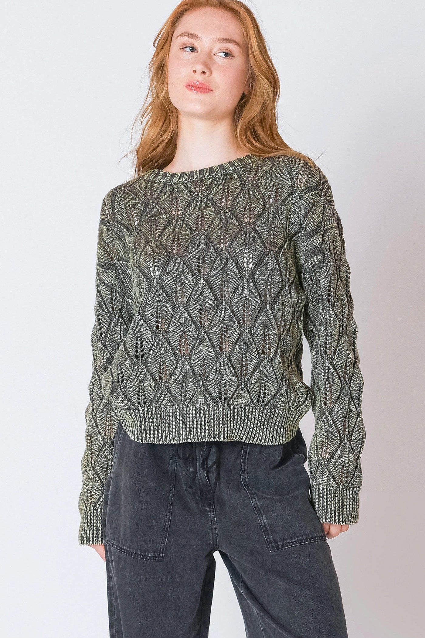 Woman wearing a green patterned sweater against a white background