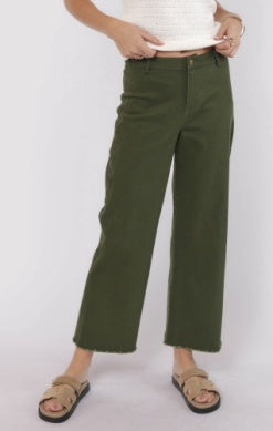 Person wearing green pants and a white top on a white background