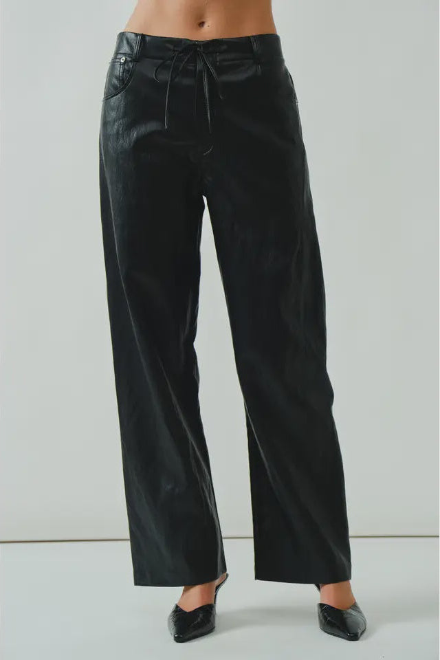 Black pants worn by a person on a white background