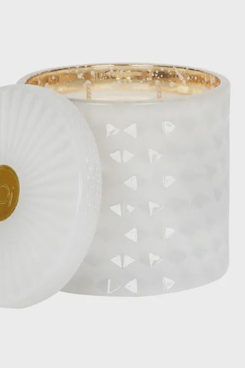 White candle with decorative lid on a light gray background