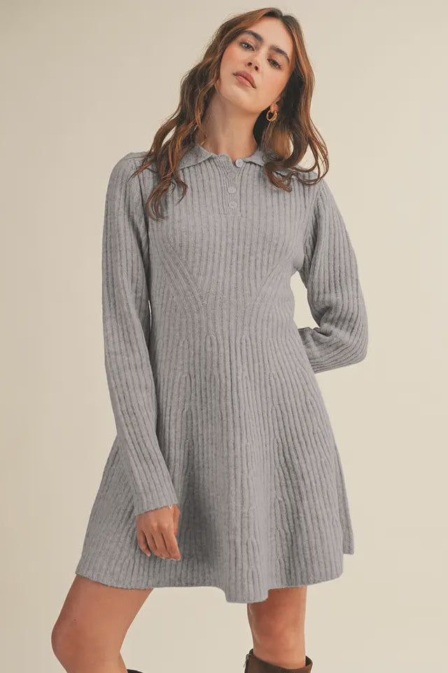 Woman wearing a gray ribbed dress against a beige background